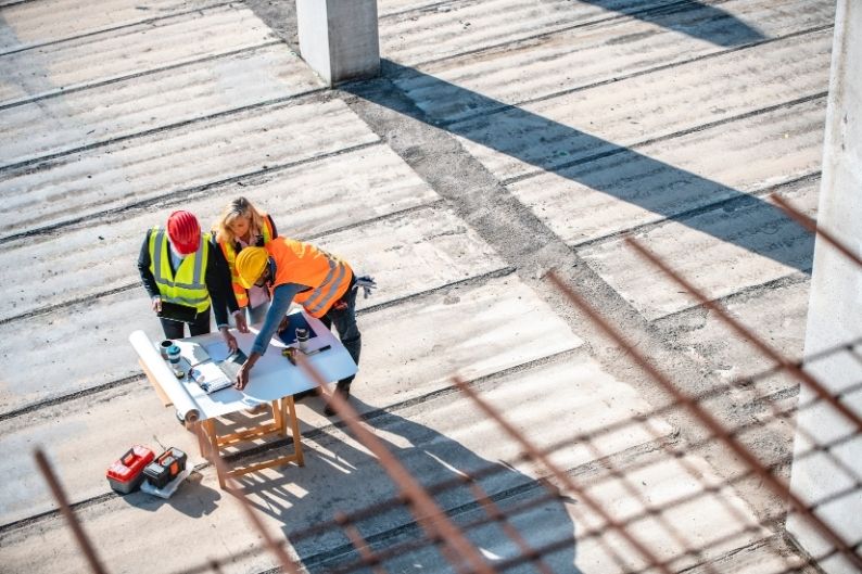 urbaniste et maitre d'ouvrage font une réunion sur le chantier pour le suivi de travaux